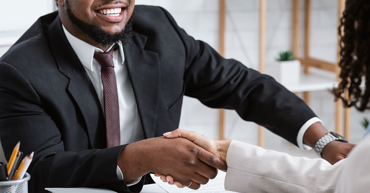 man shaking woman's hand giving good news and agreeing