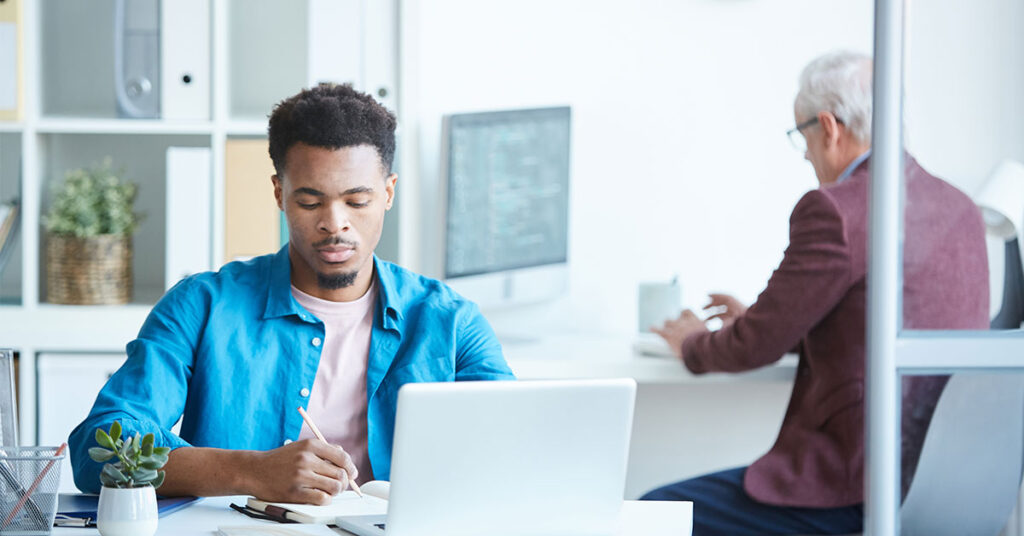 two men working on their computers in their office