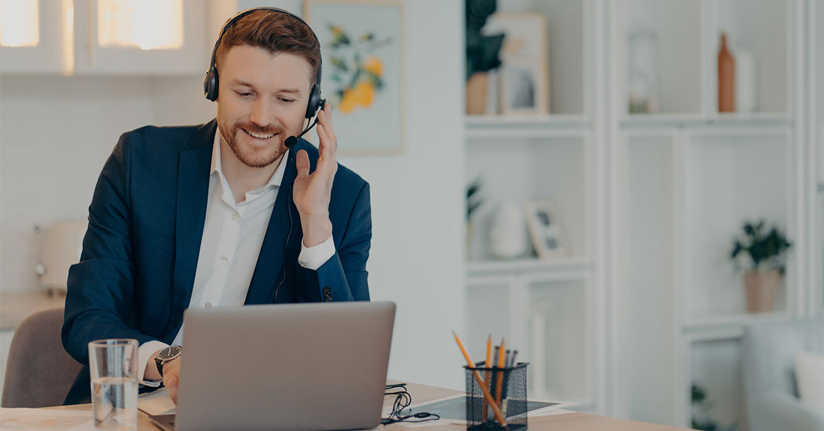 man working from home and taking into a headset